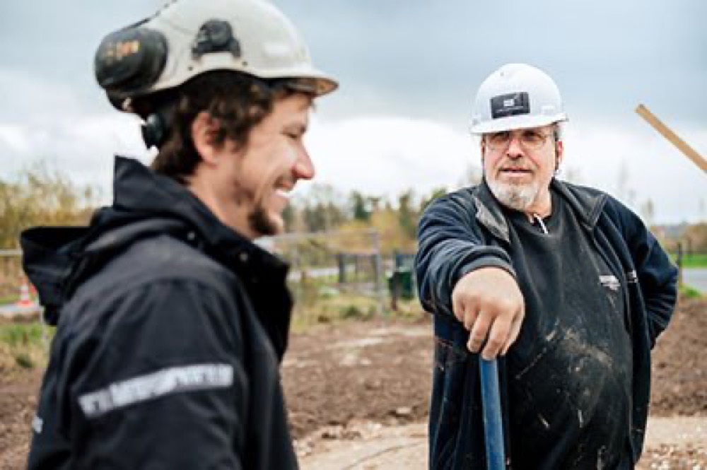 Twee collega's van Lips Aannemers overleggen op de bouwplaats